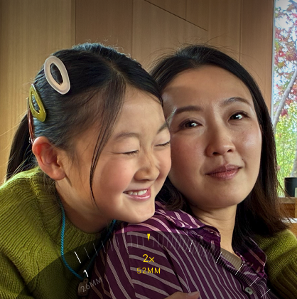 Funcția Teleobiectiv 2x activată, zoom-in pe două persoane îmbrățișate