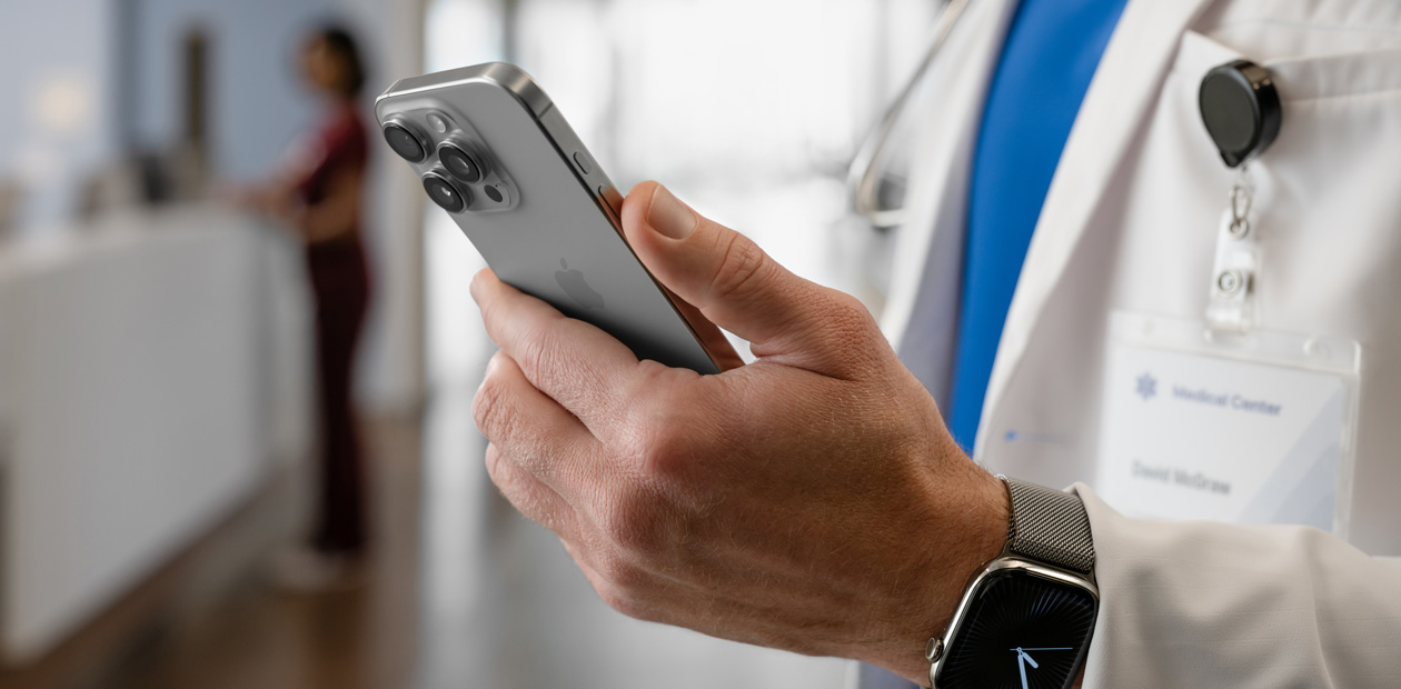 A doctor’s hands hold an iPhone.