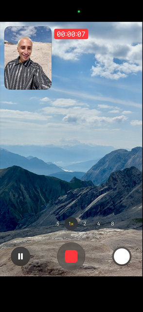 Iemand demonstreert gelijktijdige video-opname door zichzelf op te nemen met de camera aan de voorkant en tegelijkertijd de bergen op te nemen met de camera aan de achterkant