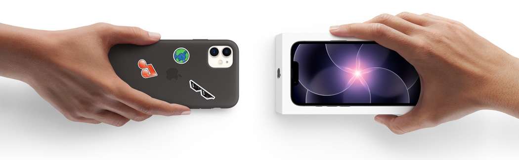 Una mano sostiene un iPhone 11 en una carcasa de silicona con stickers en la parte trasera y, al lado, una mano sostiene un nuevo iPhone 17e dentro de su caja para hacer el Trade In