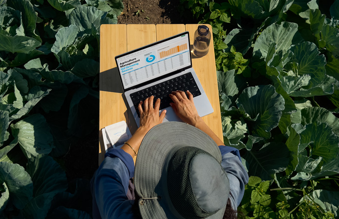 En person bruger en MacBook Pro med skærm med nanotekstur udendørs, så man kan se, at der er mindre genskin