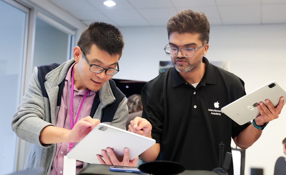 Two students collaborate with iPad devices in a classroom setting